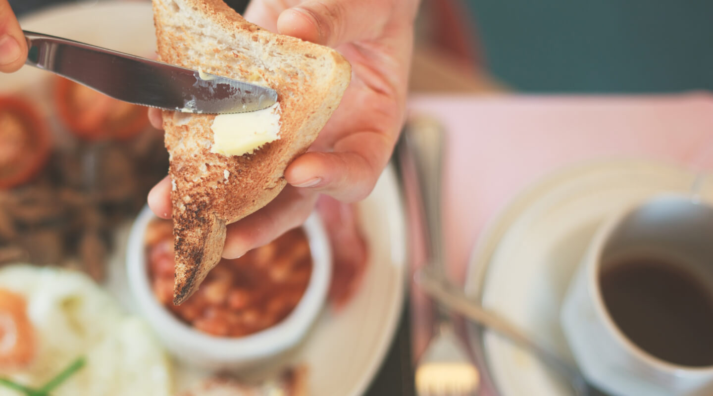 a person buttering their toast